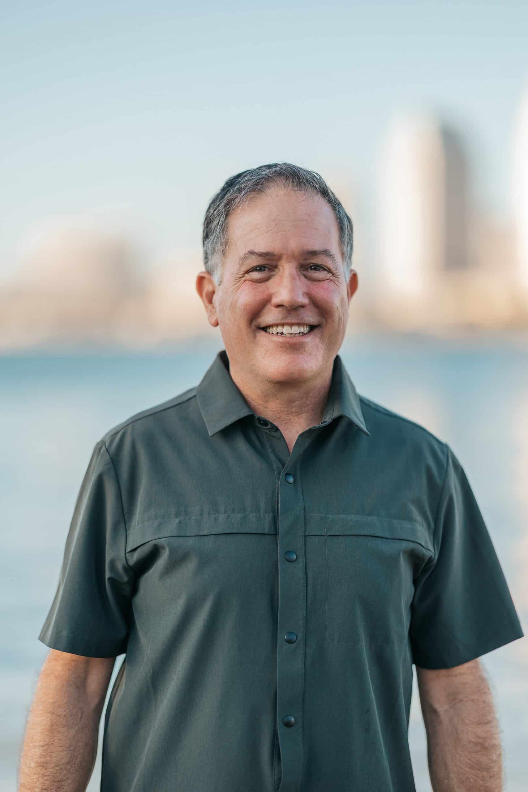 Portrait of a smiling real estate agent in casual attire outdoors.