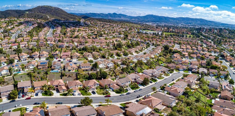Suburban neighborhood with houses, streets, and mountain backdrop in a peaceful community.