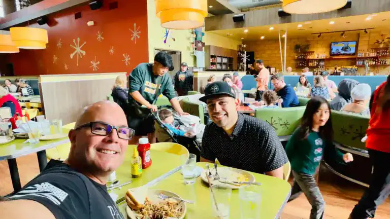Lively restaurant scene with smiling guests and colorful decor.